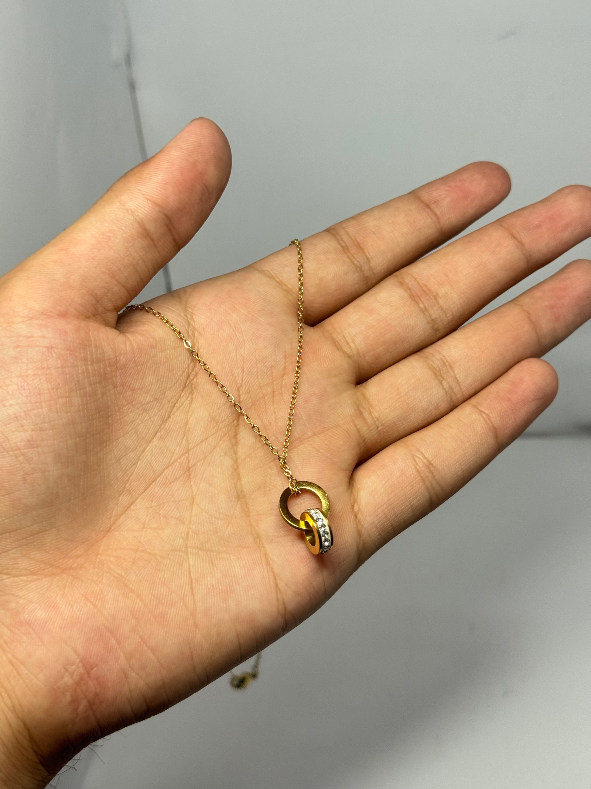 Elegant Interlocking Gold-Tone Pendant Necklace with Crystal Detailing - Glimzie